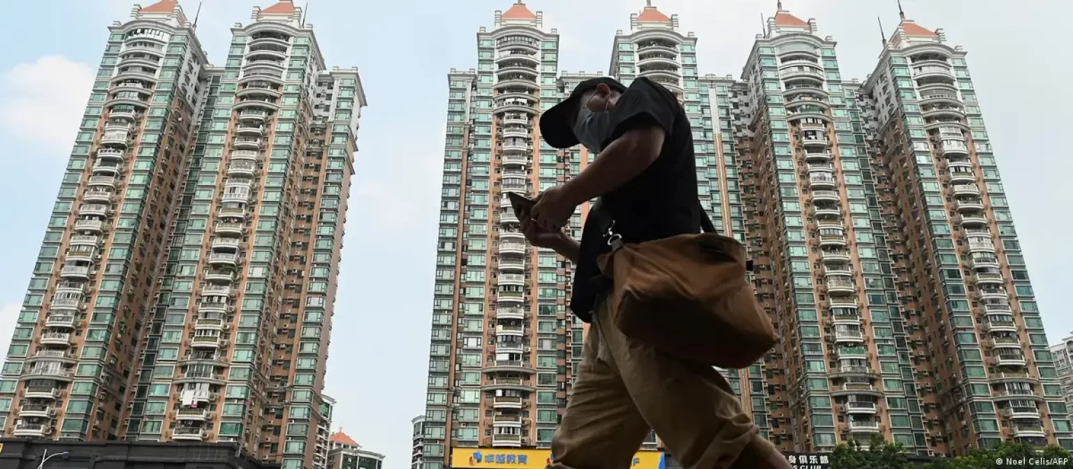 man walking in front of chinese apartment development