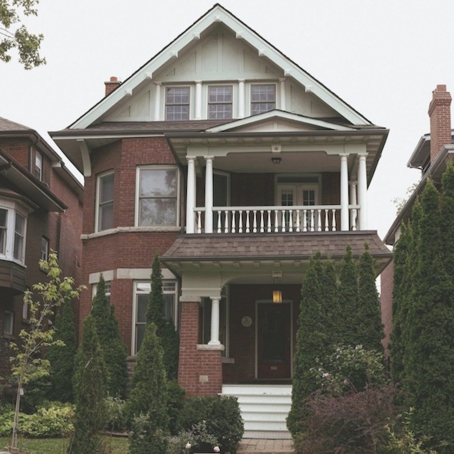 early 20th century New England brick row house steps to the front door and 2nd floor porch